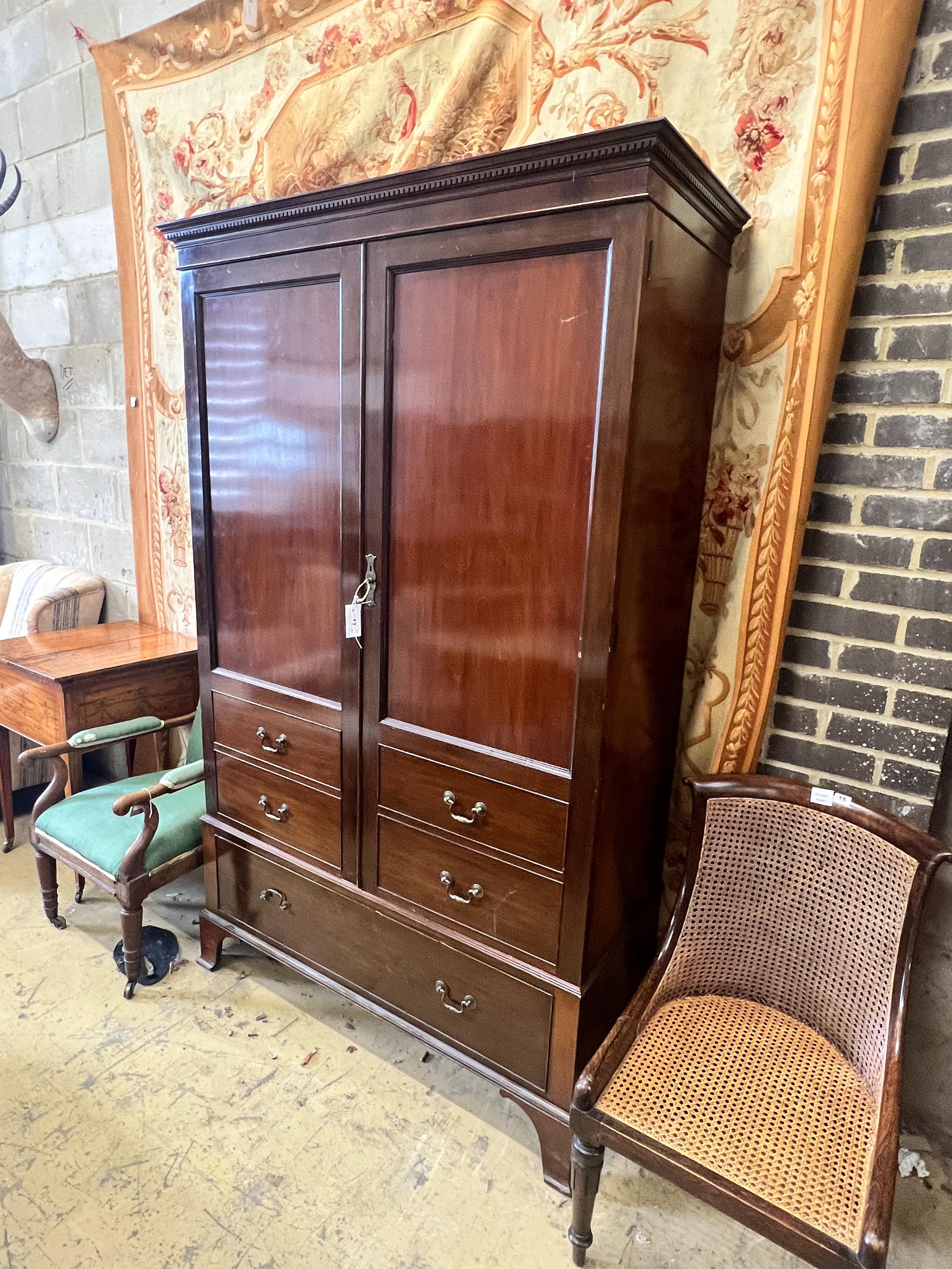 A 1920's mahogany press cupboard with part dummy drawer front over a single drawer, width 120cm, depth 50cm, height 196cm